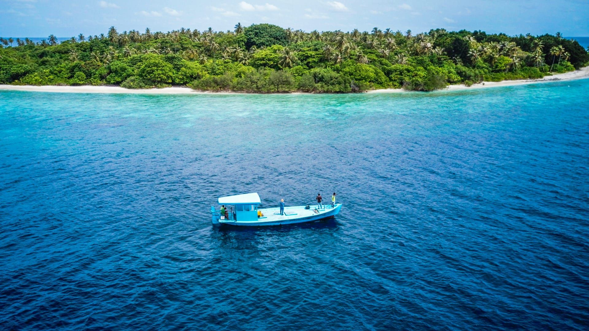 A dive boat on turquoise water off an island