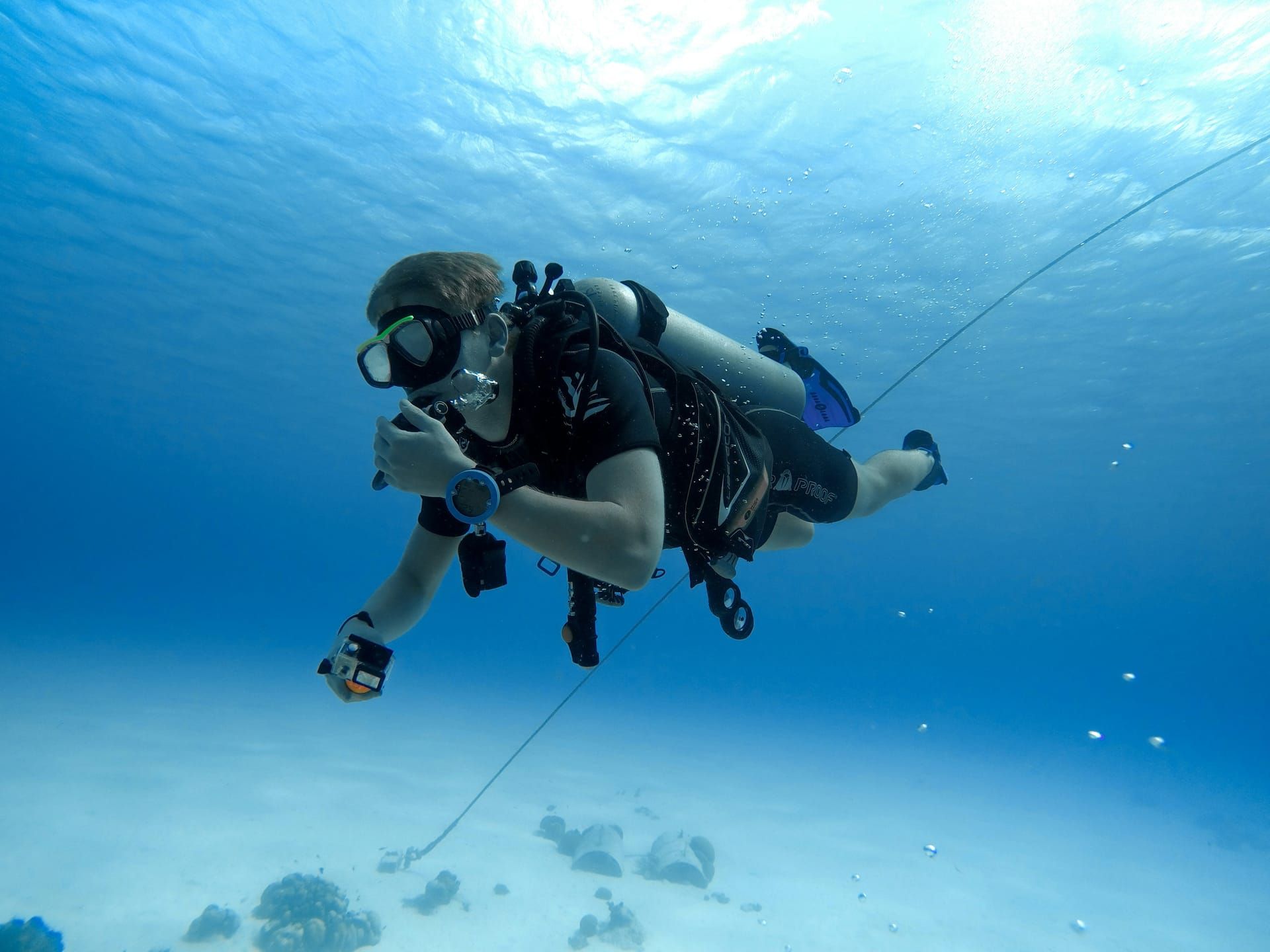 A diver following the line in clear water